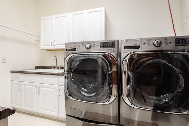 clothes washing area featuring cabinet space, a sink, and washing machine and clothes dryer