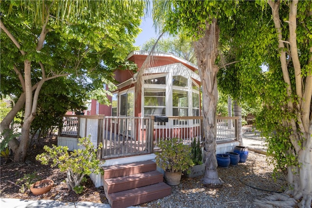 view of front of property featuring a sunroom and a deck