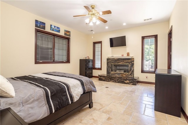 bedroom featuring recessed lighting, a fireplace, visible vents, baseboards, and stone tile flooring