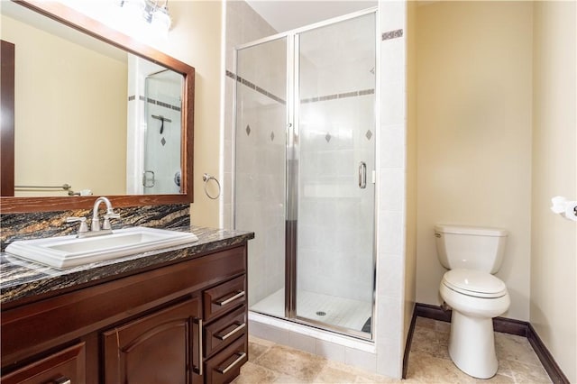 bathroom featuring toilet, a shower stall, and vanity