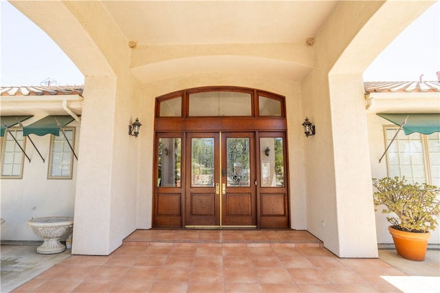 entrance to property featuring french doors and stucco siding