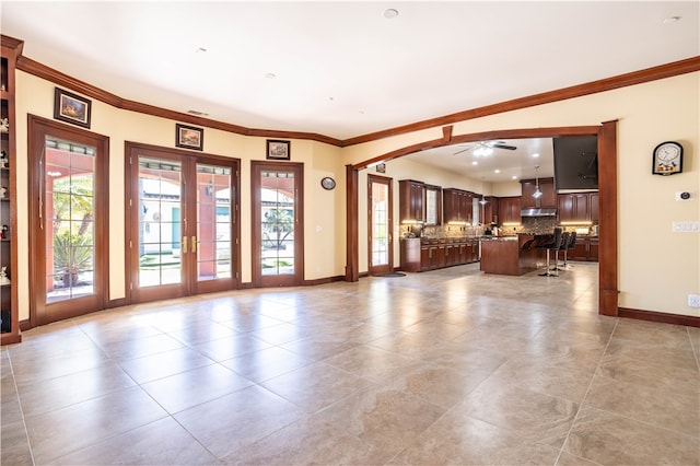 unfurnished living room with ceiling fan, light tile patterned floors, baseboards, french doors, and crown molding