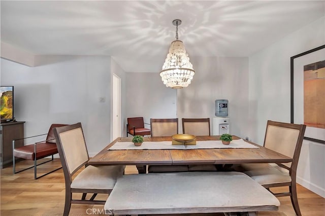 dining area featuring an inviting chandelier and light hardwood / wood-style flooring