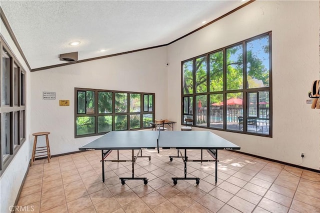 recreation room featuring light tile patterned flooring, ornamental molding, a textured ceiling, and vaulted ceiling