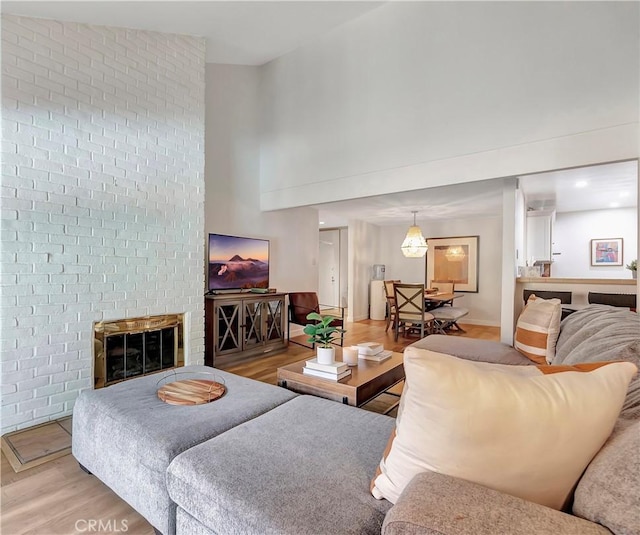 living room featuring a fireplace, light hardwood / wood-style floors, and vaulted ceiling