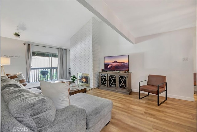 living room featuring a fireplace, lofted ceiling, and hardwood / wood-style flooring