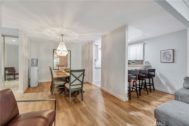 dining space with a chandelier and light wood-type flooring