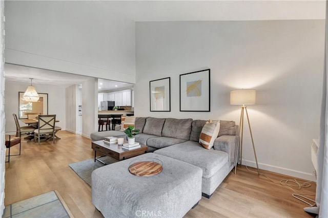 living room with high vaulted ceiling and light hardwood / wood-style flooring