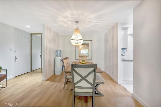 dining room featuring light wood-type flooring and an inviting chandelier