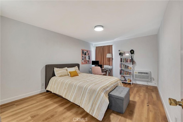 bedroom with an AC wall unit and hardwood / wood-style floors