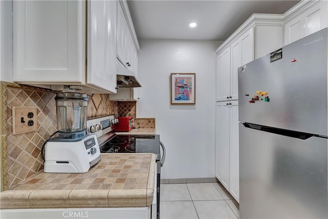 kitchen featuring tile countertops, white cabinetry, electric stove, and stainless steel refrigerator