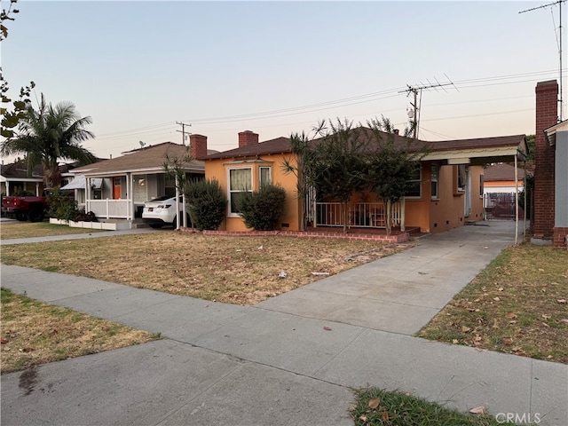 ranch-style house featuring a carport and a lawn