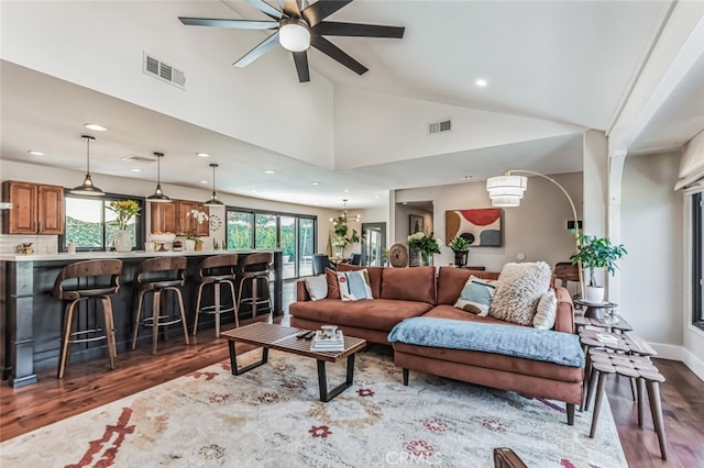 living room with ceiling fan, a healthy amount of sunlight, dark hardwood / wood-style flooring, and high vaulted ceiling