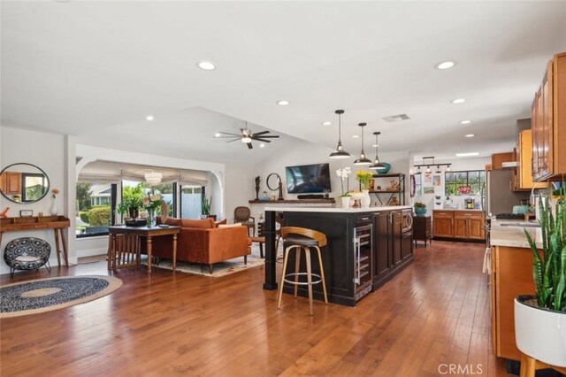 kitchen with vaulted ceiling, a center island, ceiling fan, pendant lighting, and dark hardwood / wood-style floors