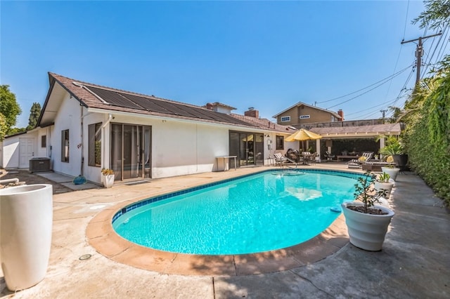 view of swimming pool with central AC unit, a pergola, and a patio