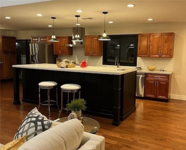 kitchen featuring pendant lighting, sink, backsplash, stainless steel appliances, and dark hardwood / wood-style flooring