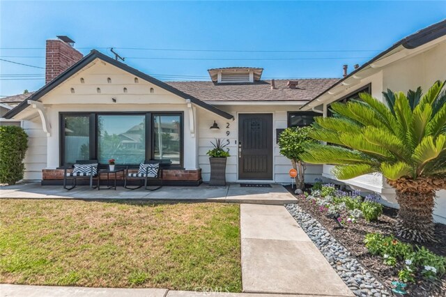 property entrance with a lawn and a patio area