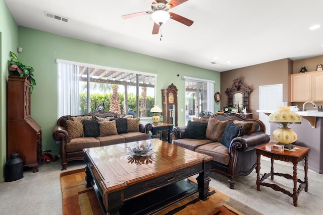 living room with ceiling fan, sink, and carpet floors