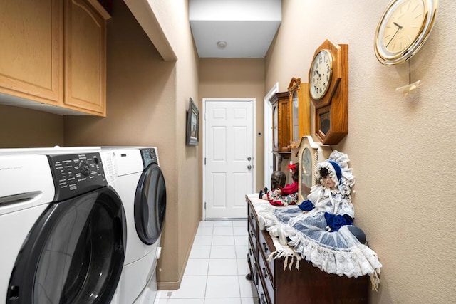 clothes washing area with cabinets, independent washer and dryer, and light tile patterned floors