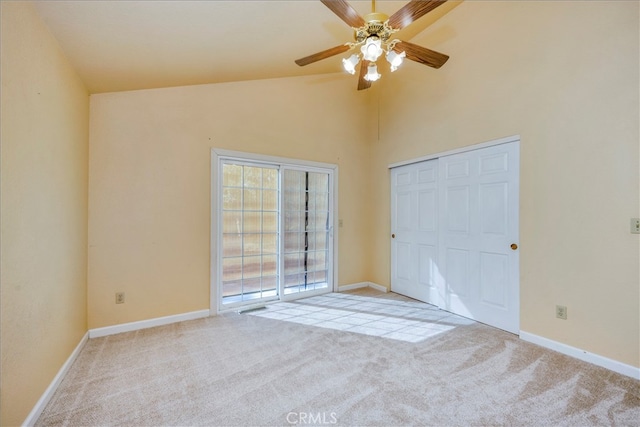 unfurnished bedroom with ceiling fan, light colored carpet, a closet, and high vaulted ceiling