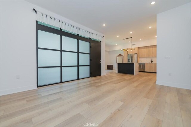 unfurnished living room with light wood-type flooring