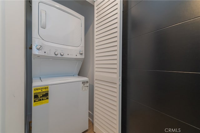 clothes washing area featuring stacked washer and clothes dryer