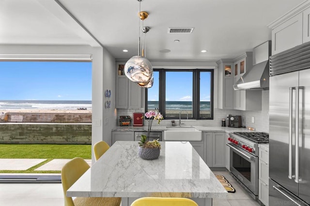 kitchen with high end appliances, sink, a kitchen bar, and backsplash