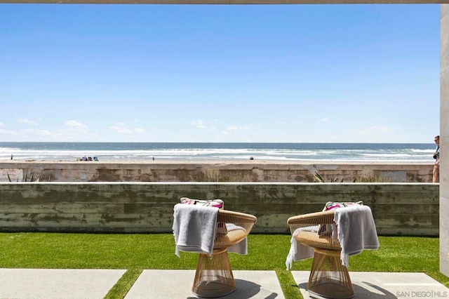 view of yard featuring a water view and a beach view