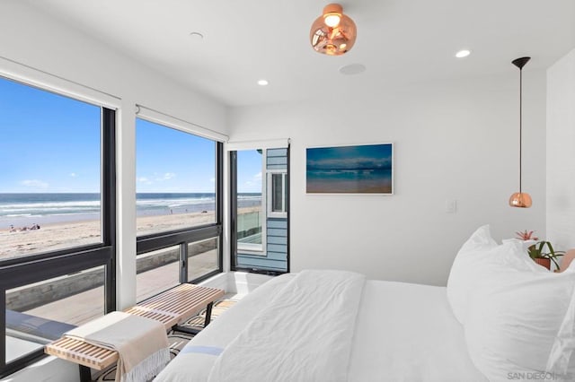 bedroom featuring a view of the beach and a water view