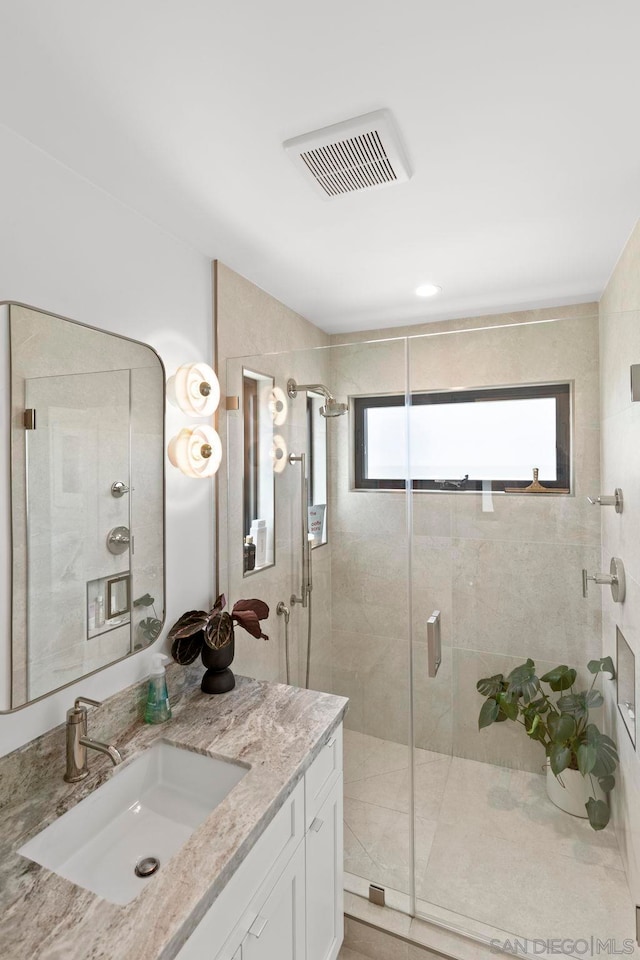 bathroom featuring vanity and a shower with shower door