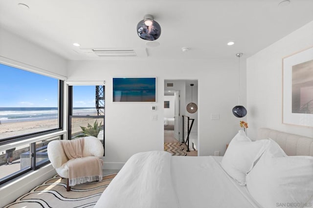 bedroom featuring a water view and multiple windows