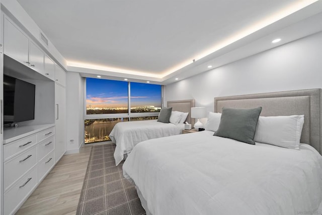 bedroom featuring a tray ceiling and wood-type flooring