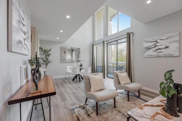 sitting room featuring light hardwood / wood-style flooring and a high ceiling