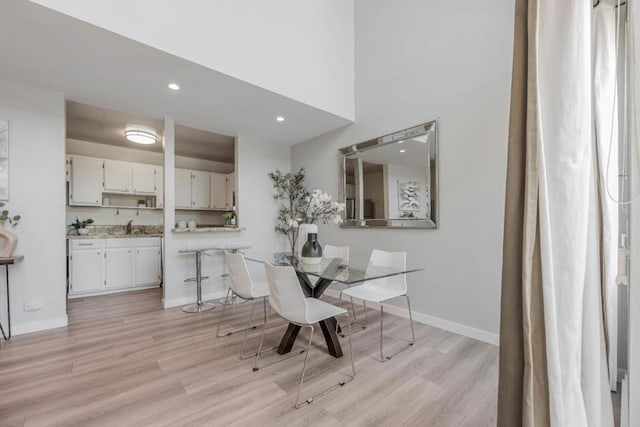 dining space with sink and light hardwood / wood-style floors