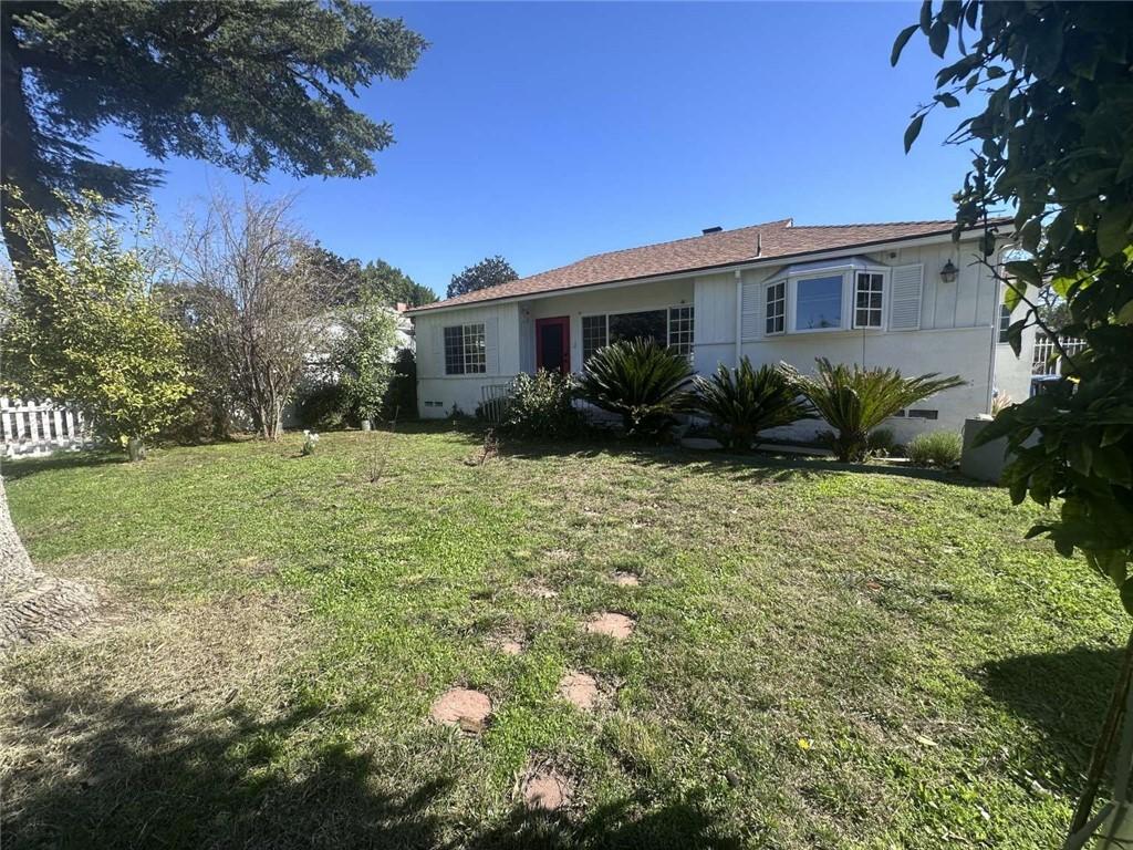 view of front facade featuring a front yard and fence