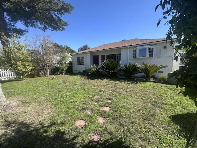 view of front facade featuring a front yard and fence