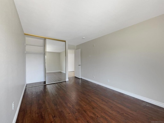 unfurnished bedroom featuring a closet and dark hardwood / wood-style floors