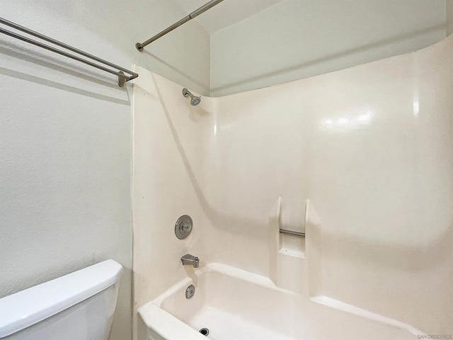 bathroom with bathtub / shower combination and toilet