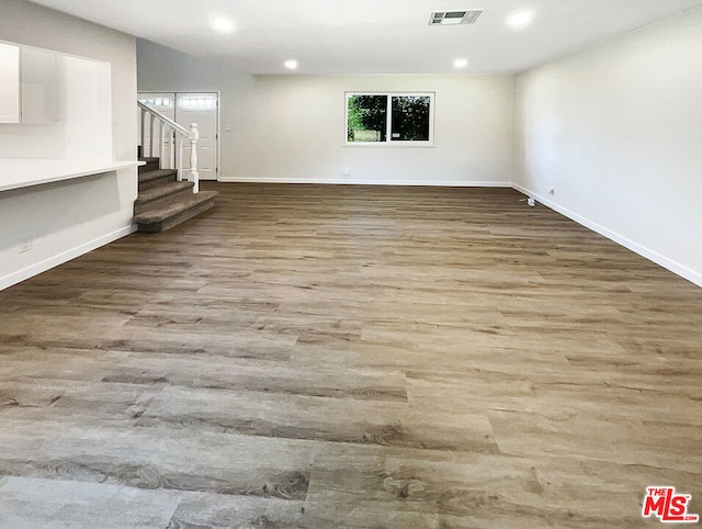 basement featuring light wood-type flooring and a healthy amount of sunlight