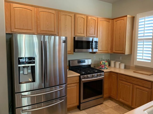 kitchen with light tile patterned floors, stainless steel appliances, and a healthy amount of sunlight