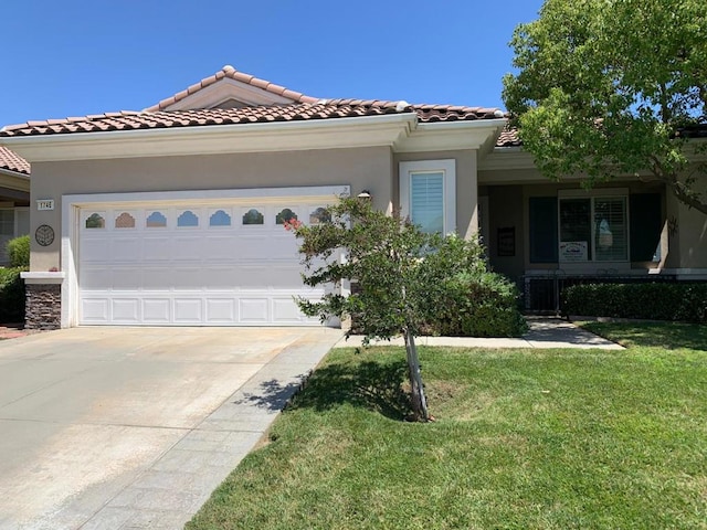 mediterranean / spanish-style house with a front yard and a garage