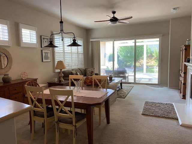 carpeted dining room with ceiling fan