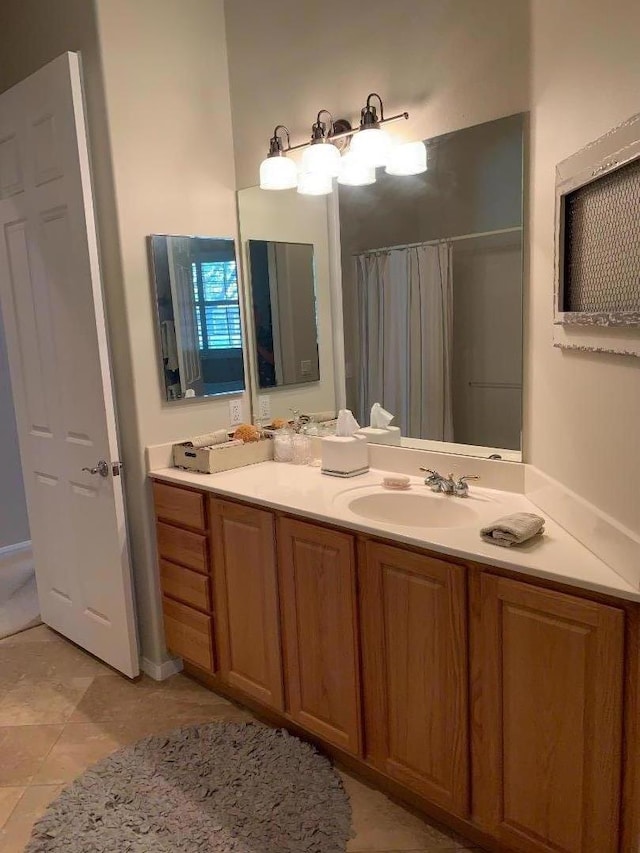 bathroom featuring tile patterned flooring, walk in shower, and vanity