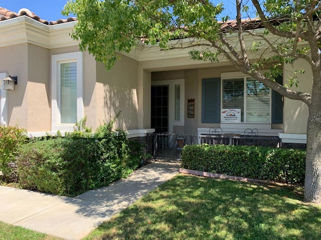 entrance to property with a lawn