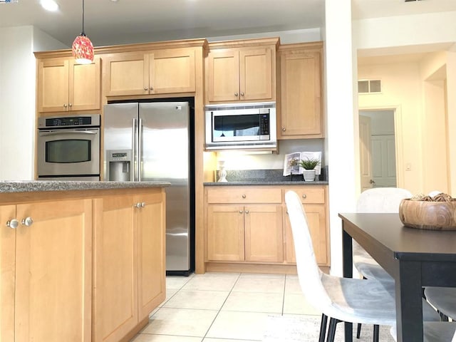 kitchen featuring light tile patterned flooring, stainless steel appliances, and hanging light fixtures