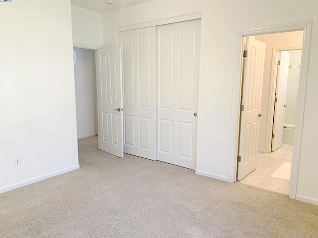 unfurnished bedroom with light carpet and a closet