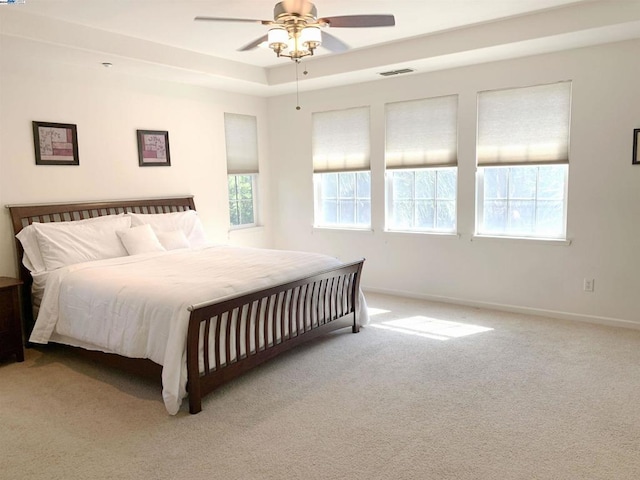 carpeted bedroom with ceiling fan and multiple windows