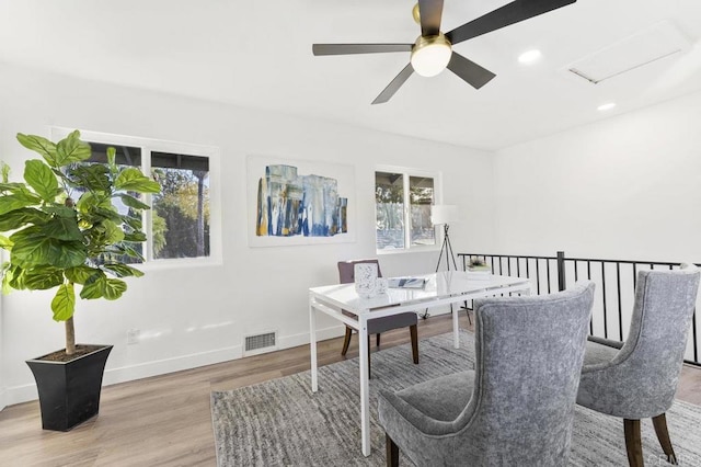 home office with a healthy amount of sunlight, baseboards, visible vents, and wood finished floors