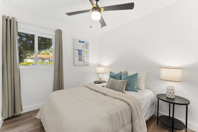 bedroom with wood finished floors, a ceiling fan, and baseboards