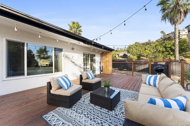 wooden terrace with fence and an outdoor living space